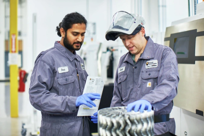 Burloak technicians inspecting a 3D printed metal component